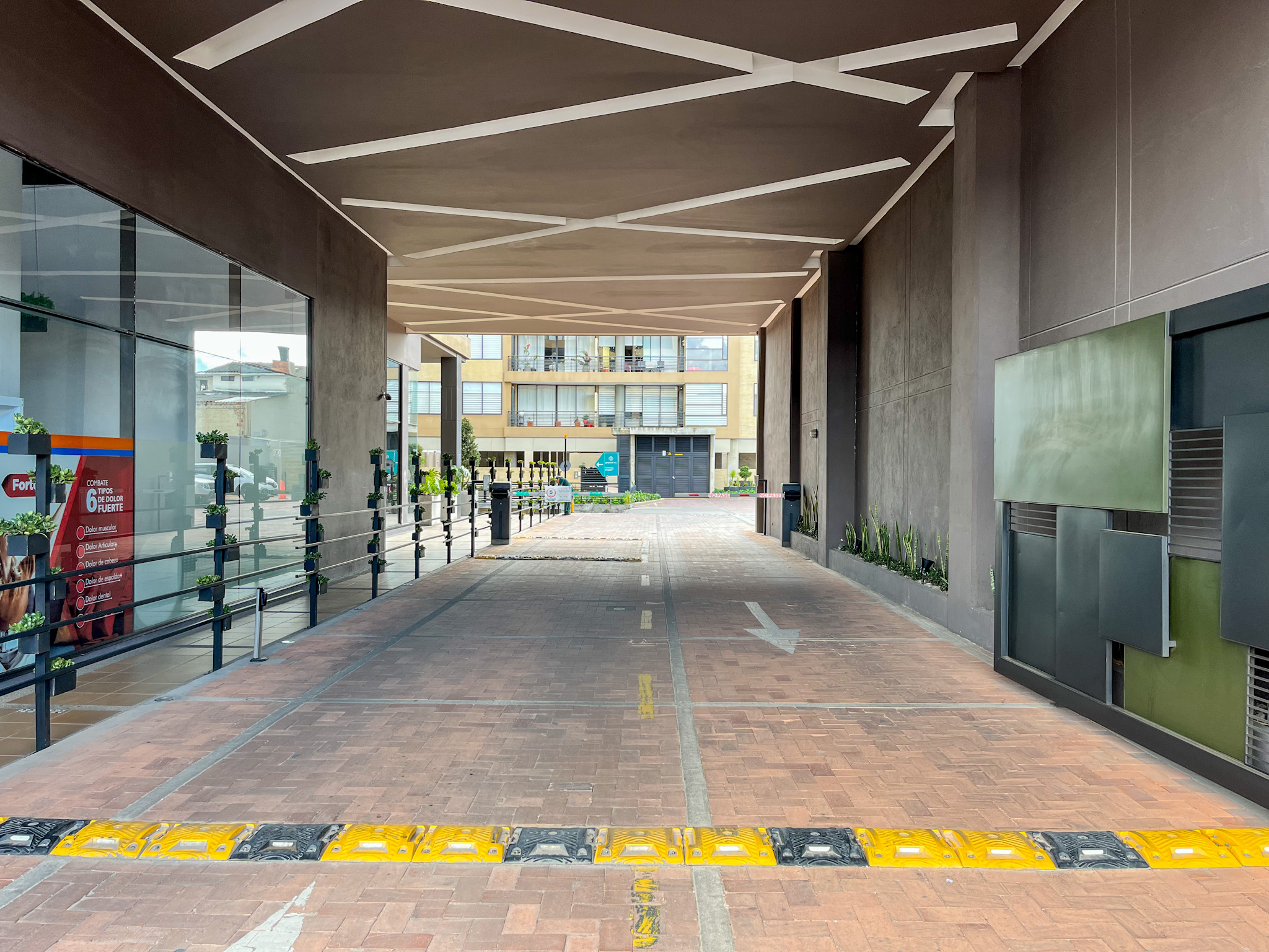Acceso vehicular cubierto con cubierta de diseño angular